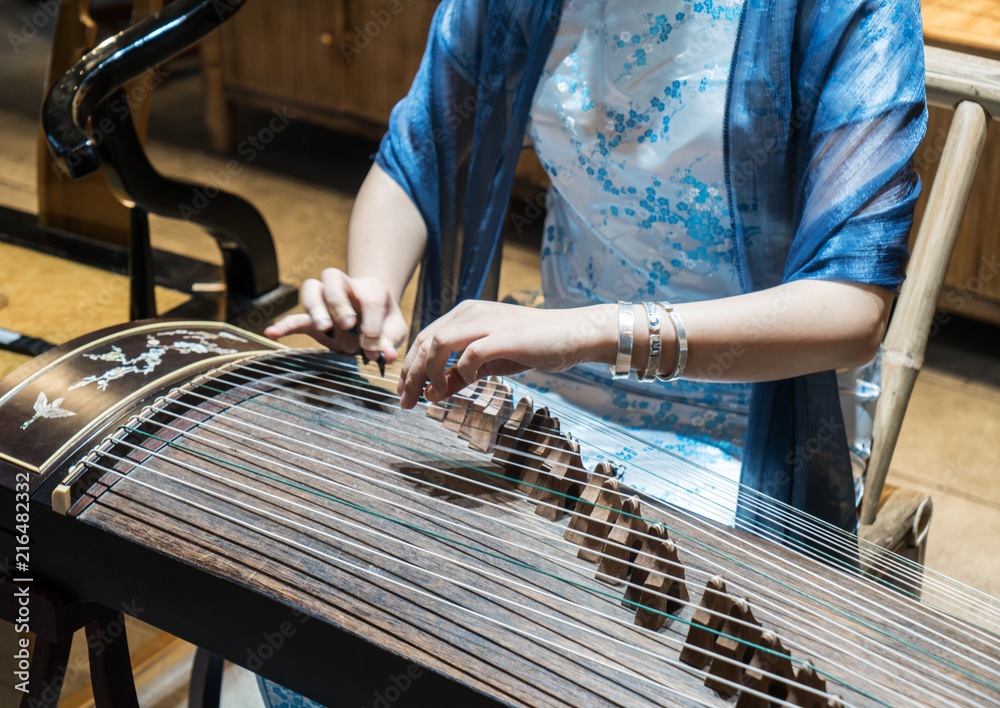 hand of man playing Guzheng.The guzheng or gu zheng, also simply called  zheng, is a Chinese instrument Stock Photo | Adobe Stock