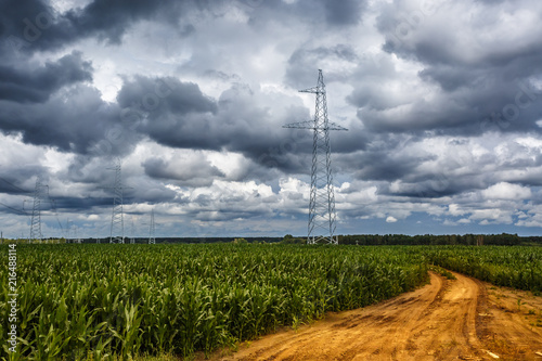 Silhouette of the high voltage electric pylon towers on the background on yellow road with beautiful clouds photo