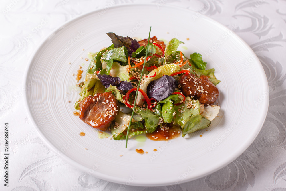 Bowl of salad with beef teriyaki and vegetables. Asian food. Salad on a white dish on table. restaurant menu Bowl of salad with beef teriyaki and vegetables. Asian food. Salad on a white dish on table. restaurant menu