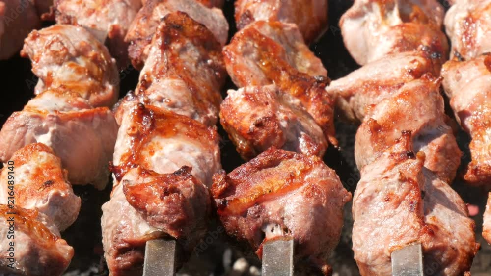 Delicious succulent meat of shish kebab on skewer fry on smoke Delicious succulent meat of shish kebab on skewer fry on smoke