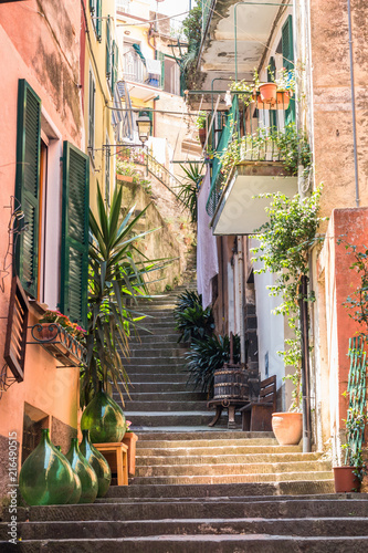 Characteristic Italian village street with stairway leading up to the end.  Potted plants and decor line the street.  
