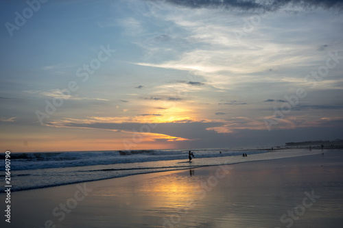 people on tropical beach at sunset