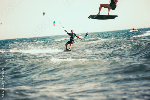 Professional kiter makes the difficult trick on a beautiful background. Kitesurfing Kiteboarding action photos man among waves quickly goes