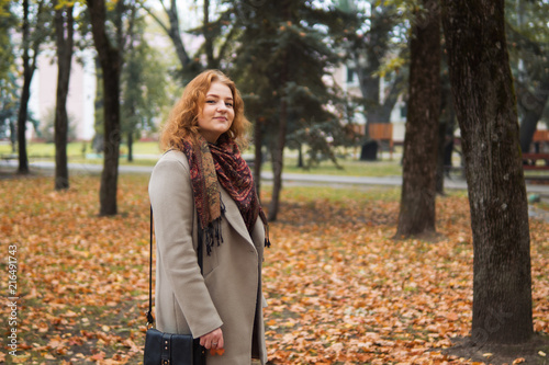 Young woman in coat walking in autumn Park