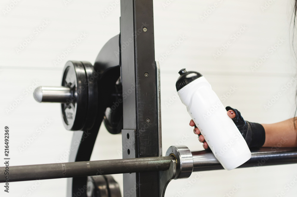 Girl holding bottle of water at gym