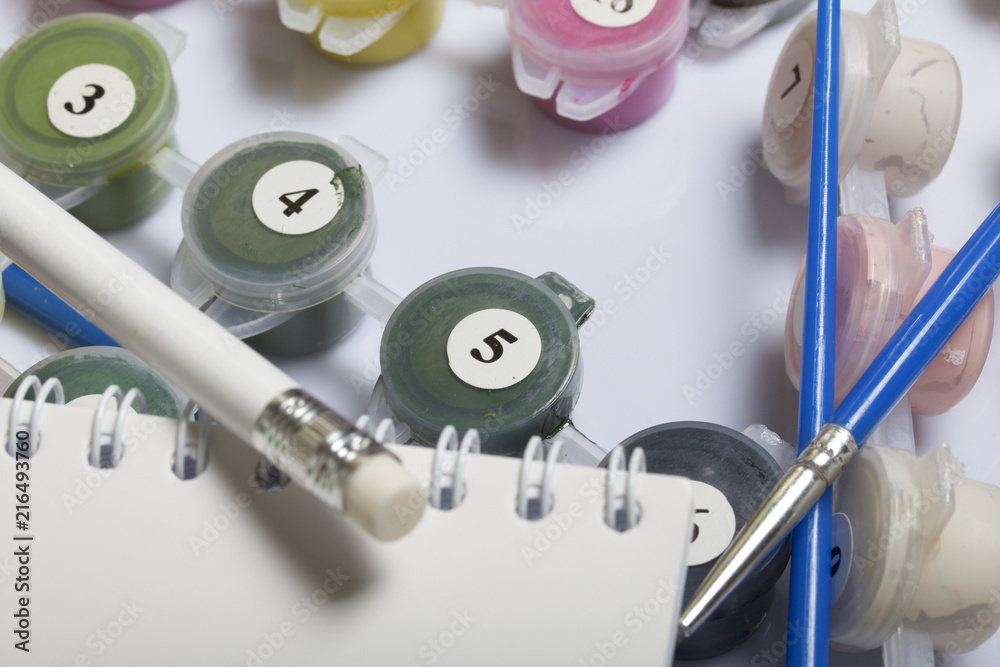 Numbered containers with paints and brushes of different sizes. For