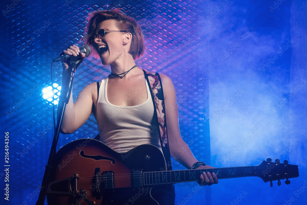 Obraz premium Female singer and guitarist at a rock concert