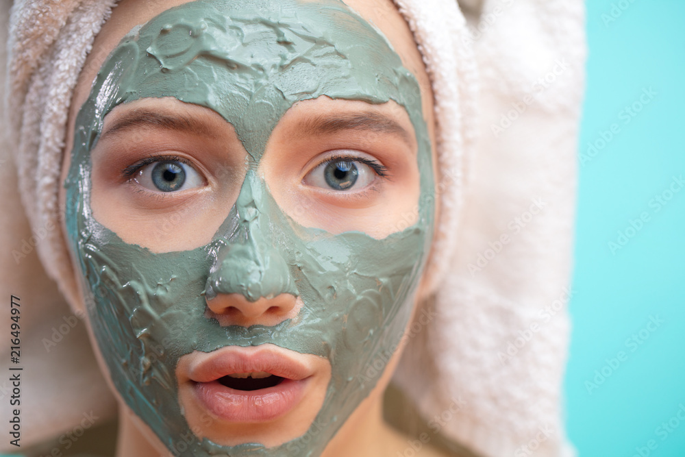 Φωτογραφία Close up portrait of surprised, shoked girl open-mouthed with towel on head and facial clay mask