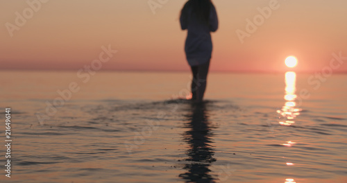 closeup teenage girl walking in shallow water on a beach