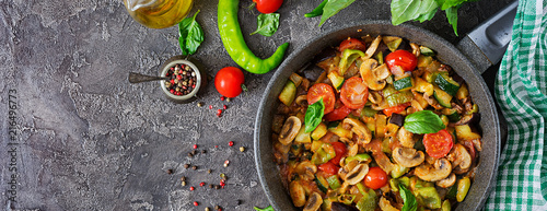 Hot spicy stew eggplant, sweet pepper, tomato, zucchini and mushrooms. Flat lay. Top view. Banner photo