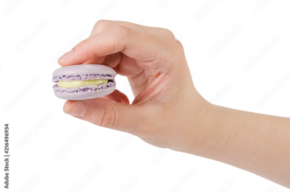 young female hand hold violet macaron isolated on white young female hand hold violet macaron isolated on white