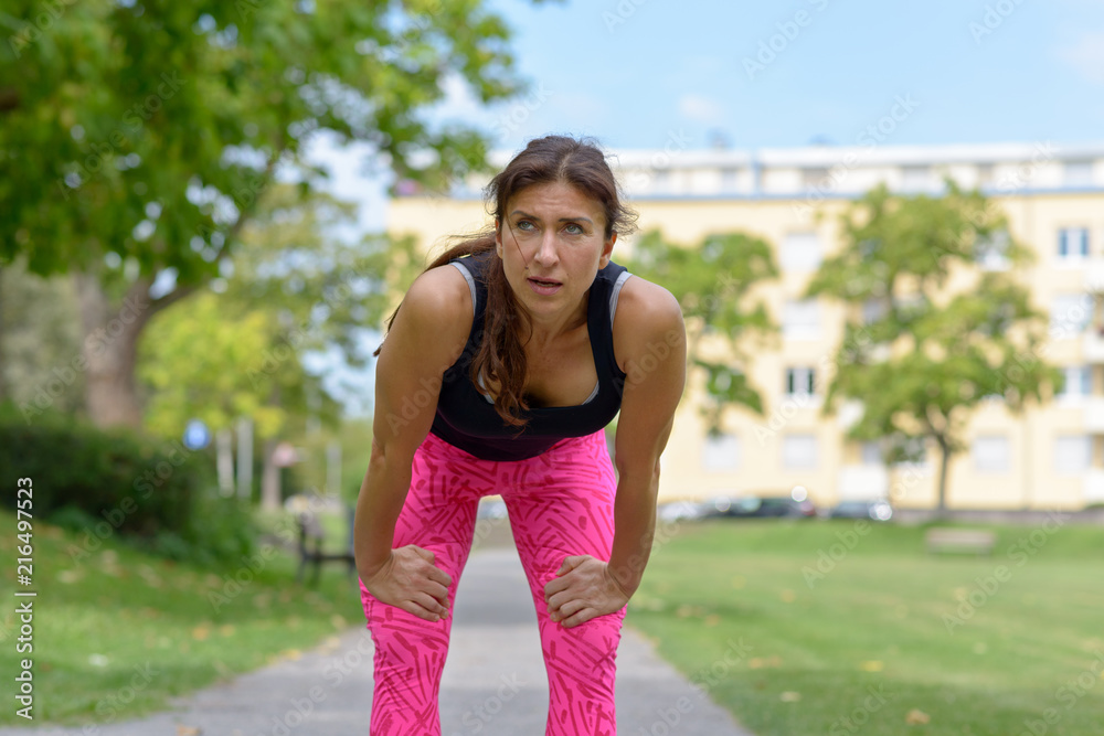 Exhausted runner leaning over with hands on knees Exhausted runner leaning over with hands on knees