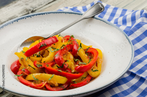 Peperonata, peppers cut into slices and cooked in a pan.  Peperonata, Italian cuisine. Roasted bell peppers with onion, tomatoes and parsley 