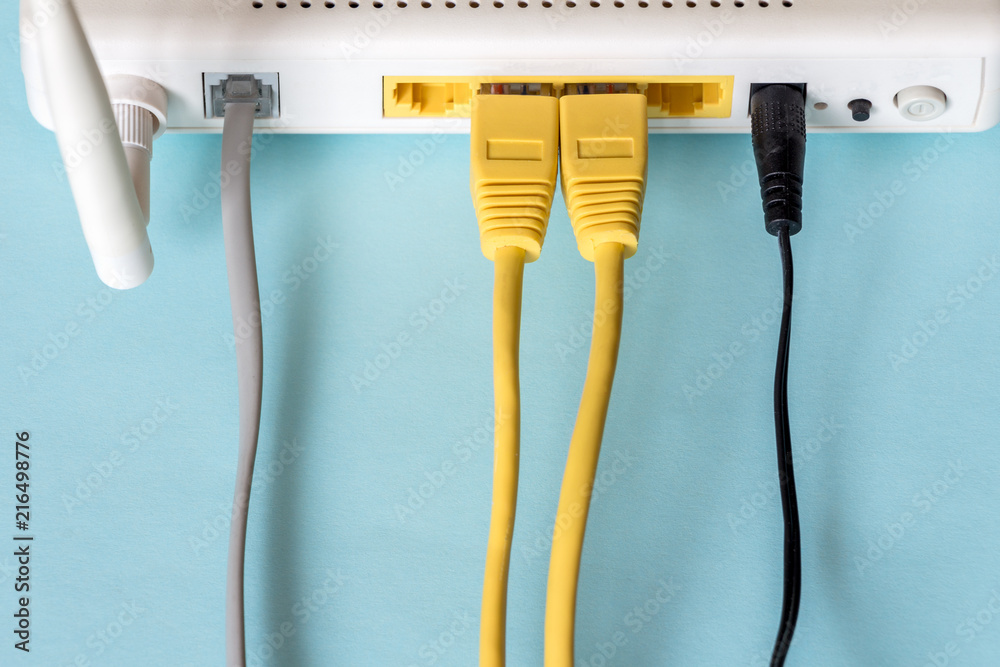 Connect an Ethernet Cable to a Wireless Router on light blue pastel.  Ethernet, rj45 and electric cables, connected to router. Network concept  foto de Stock | Adobe Stock