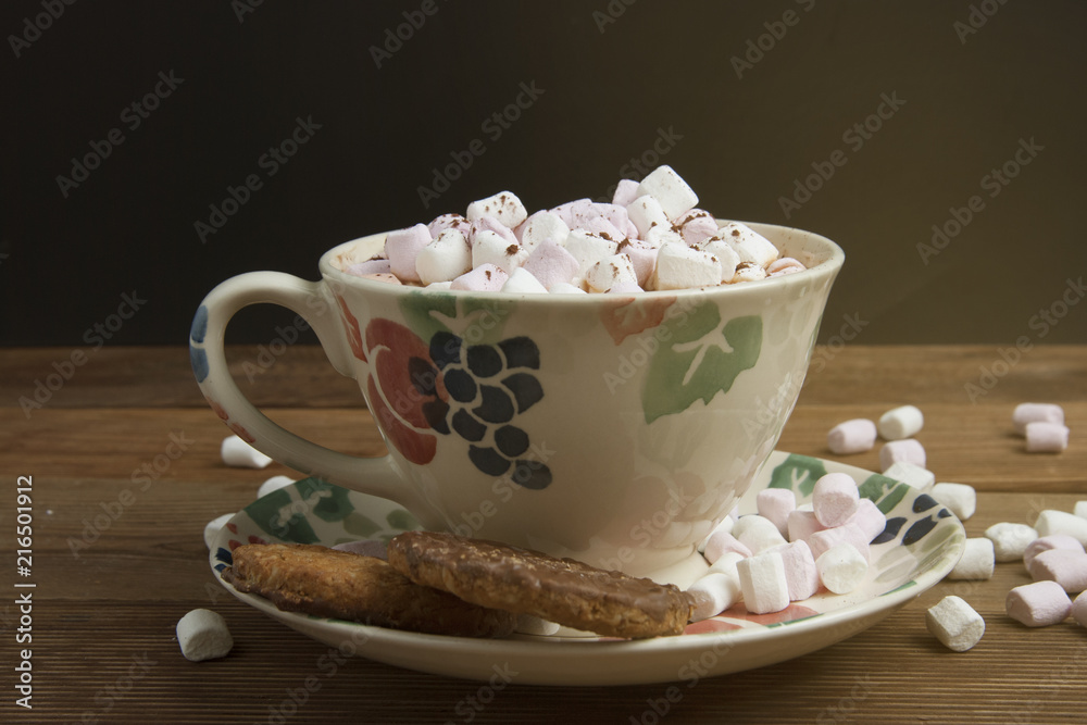 Beautiful vintage cup of homemade hot chocolate or cocoa with marshmallows, wooden table and black background. Warm sweet drink. Copy space.