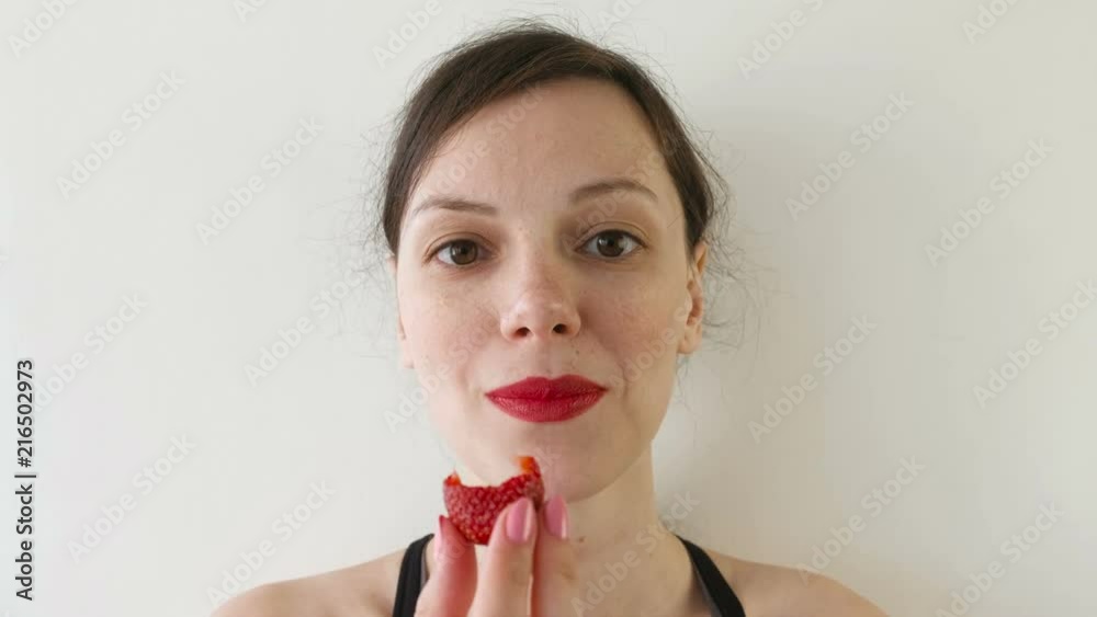 Portrait of woman eating strawberries. Front view. Portrait of woman eating strawberries. Front view.