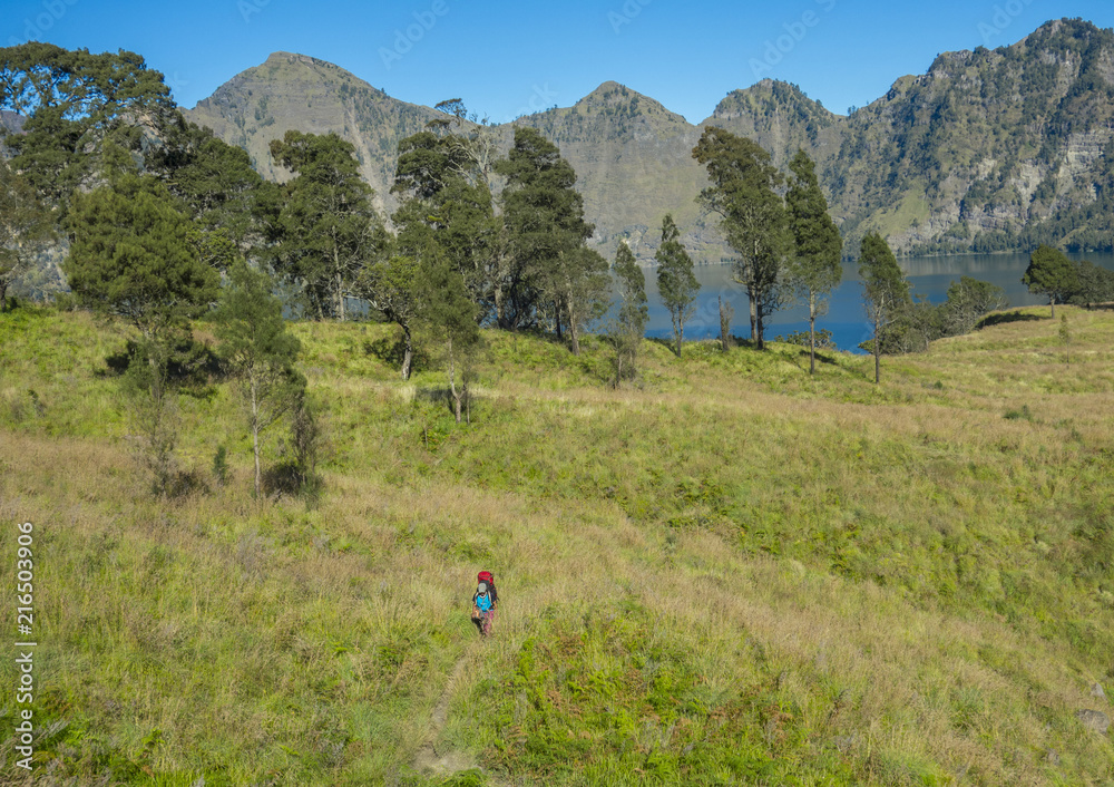 Man hikes at Segara Anak Lake (Danau) at Rinjani mountain range, Lombok, Indonesia.