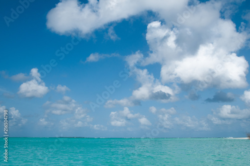 Ocean background, bright colors of turquoise water and blue sky with some clouds