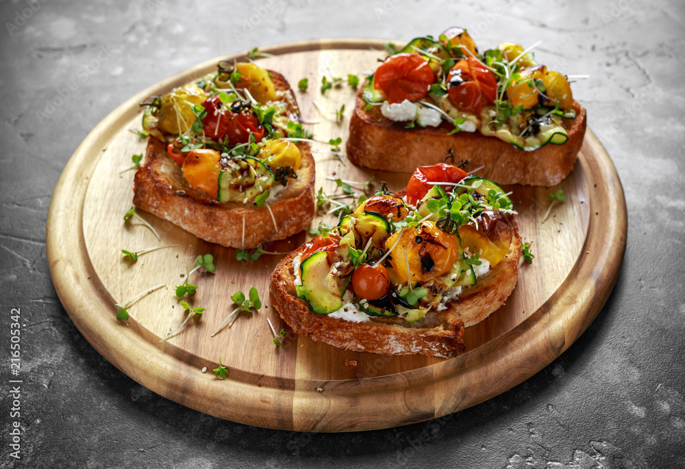 Healthy toasts with baked sweet cherry tomatoes and grilled zucchinin ribbons drizzled with balsamic vinegar Healthy toasts with baked sweet cherry tomatoes and grilled zucchinin ribbons drizzled with balsamic vinegar