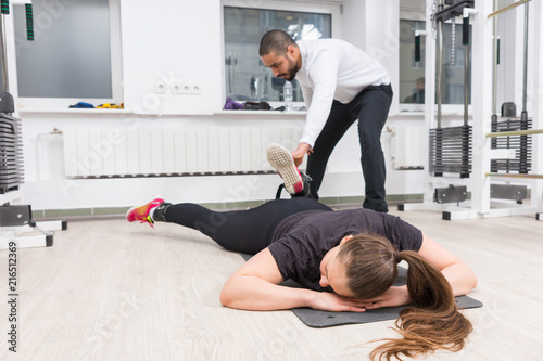 Personal trainer assisting woman at gym