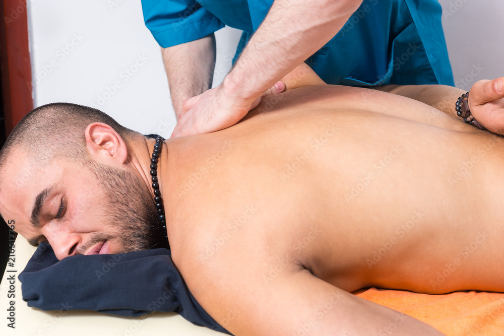 Man enjoying a back massage in a clinic Man enjoying a back massage in a clinic