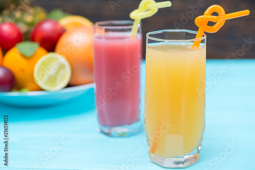 Two tall glasses of freshly squeezed fruit juice