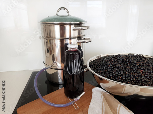 Vászonkép Black currant juice making by steam juicer pot in the kitchen