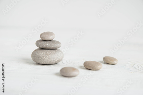 Pyramids of white zen stones with green leaves on white background. Concept of harmony  balance and meditation  spa  massage  relax
