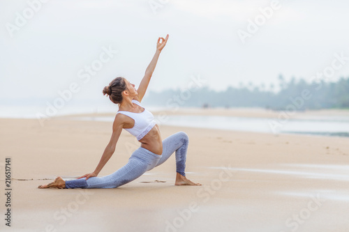 Caucasian woman practicing yoga at seashore of tropic ocean © Maygutyak