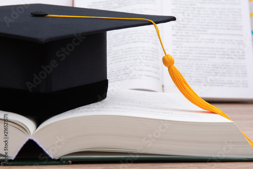 Black graduated tassel cap placed on the book. photo