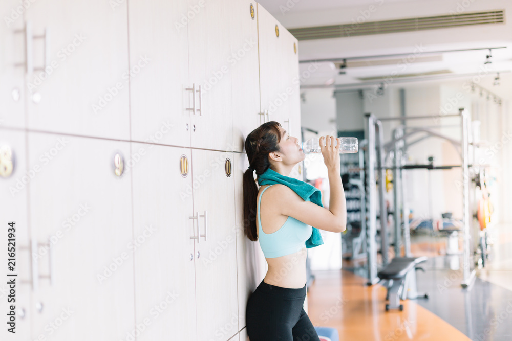 Women are drinking water after exercising in the morning gym.