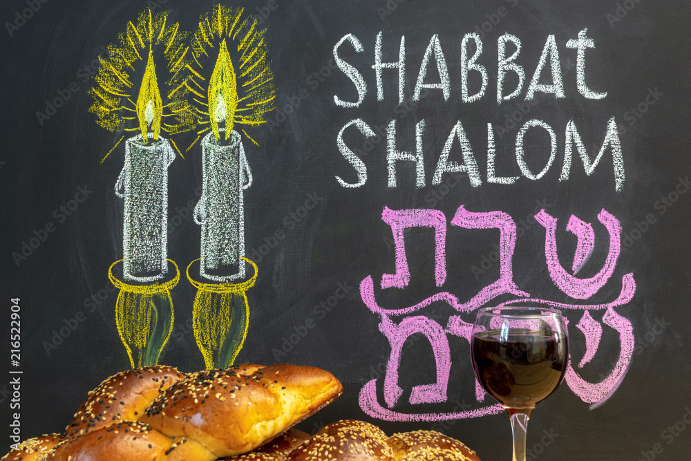 Jewish greetings Shabbat Shalom and candles painted on a chalkboard. May you dwell in completeness on this seventh day. Challah and glass of wine.