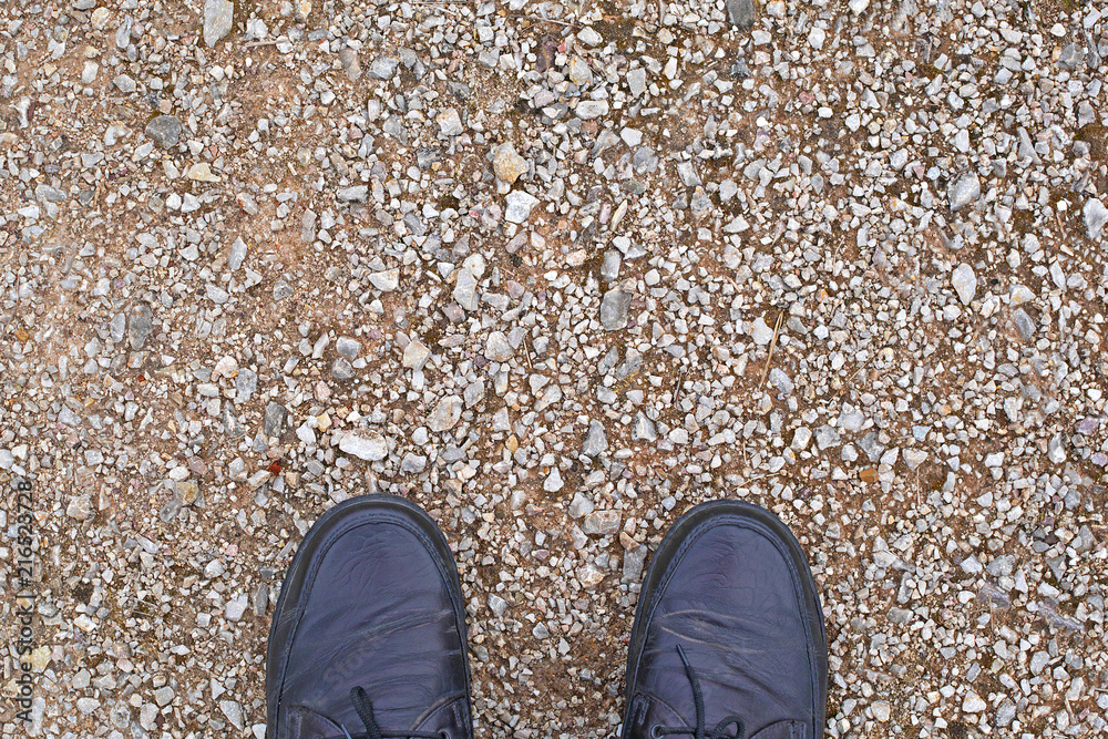 top view of men feet in leather shoes standing on country road, copy space top view of men feet in leather shoes standing on country road, copy space