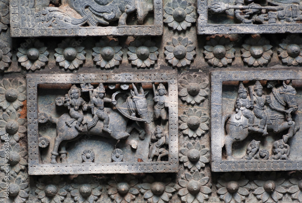 Horses and ancient riders, design on ceiling of 12th century historical stone Hindu temple, Halebidu, India.