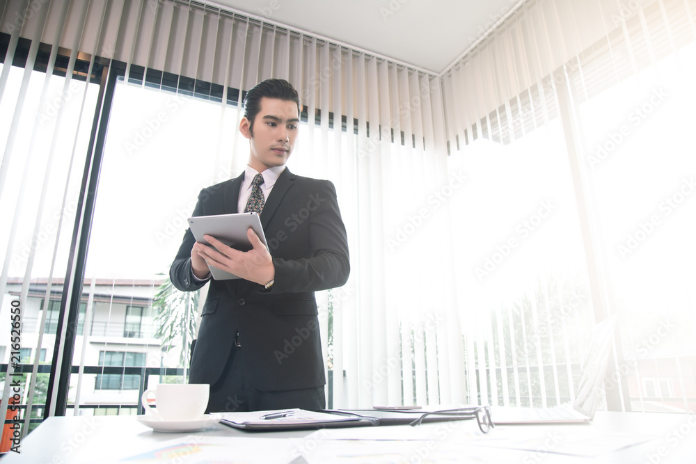 Asian Business man working at office with laptop and documents on his desk, consultant lawyer concept Asian Business man working at office with laptop and documents on his desk, consultant lawyer concept
