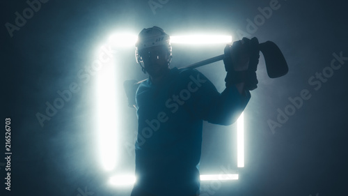 Portrait of Caucasian male ice hockey player in uniform, looking into the camera, dramatic lighting