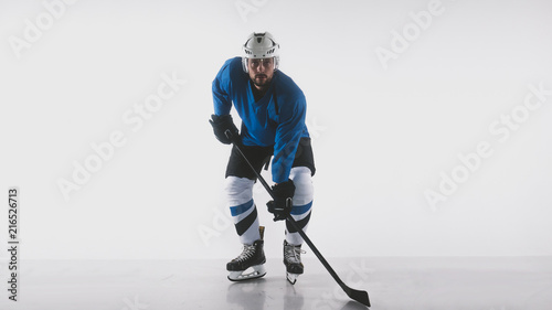 Portrait of Caucasian male ice hockey player in uniform posing against white background
