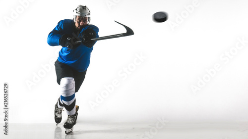 Portrait of Caucasian male ice hockey player in uniform performing a slap shot against white background