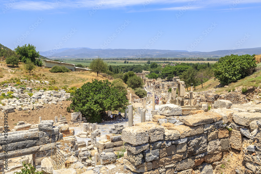 Ephesus, Izmir, Turkey - July 8, 2018 : People are walking through ancient streets of Ephesus from domitian temple to library of Celsus