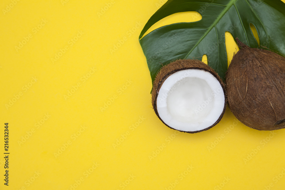 Tropical summer coconut background. half and whole coconuts on a yellow background Tropical summer coconut background. half and whole coconuts on a yellow background