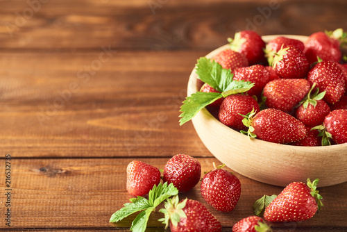 Fresh Healthy strawberry in wooden bowl over wooden background