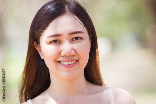 Asian women aged between 25-30 years old posting on natural blurred background close up.