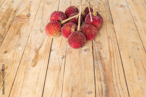 The pulasan, Nephelium mutabile Blume (family Sapindaceae), is a tropical fruit closely allied to the rambutan and sometimes confused with it on wooden table photo