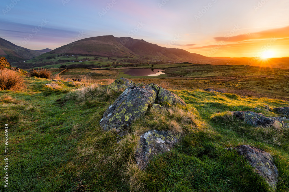 Stunning sunrise with beautiful morning light illuminating rocks in the Lake District.