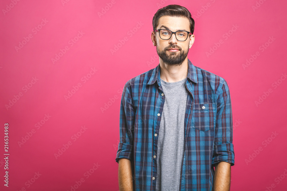 Fototapeta premium Portrait of a young man thoughtful face. Isolated on a pink background.