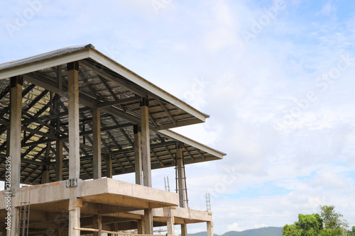 Closeup of a house is under construction with cloudy blue sky. 