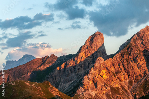 Sunset at the Passo di Giau, casting a red glow on the rugged mountains of the Italian Dolomites, on a late July evening.