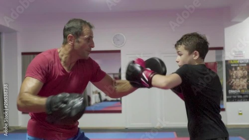 Young kickboxer hitting mitts in slow motion
