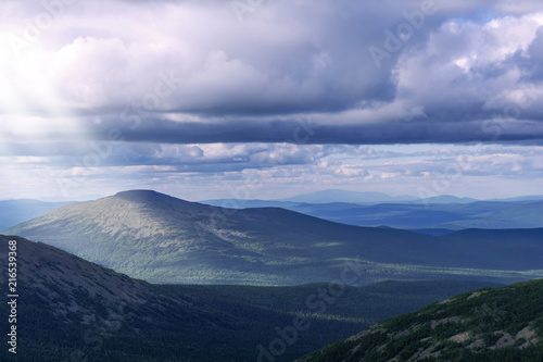 landscape of the northern mountains with beautiful sunbeams making their way from behind the clouds