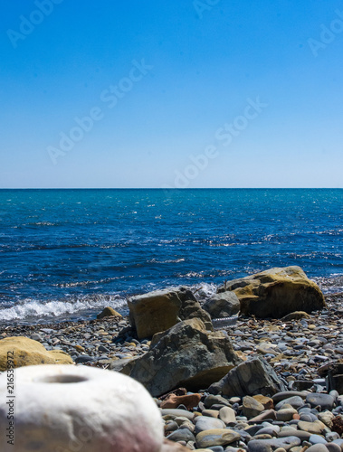rocky sea shore with pebble beach, waves with foam © Wingedbull